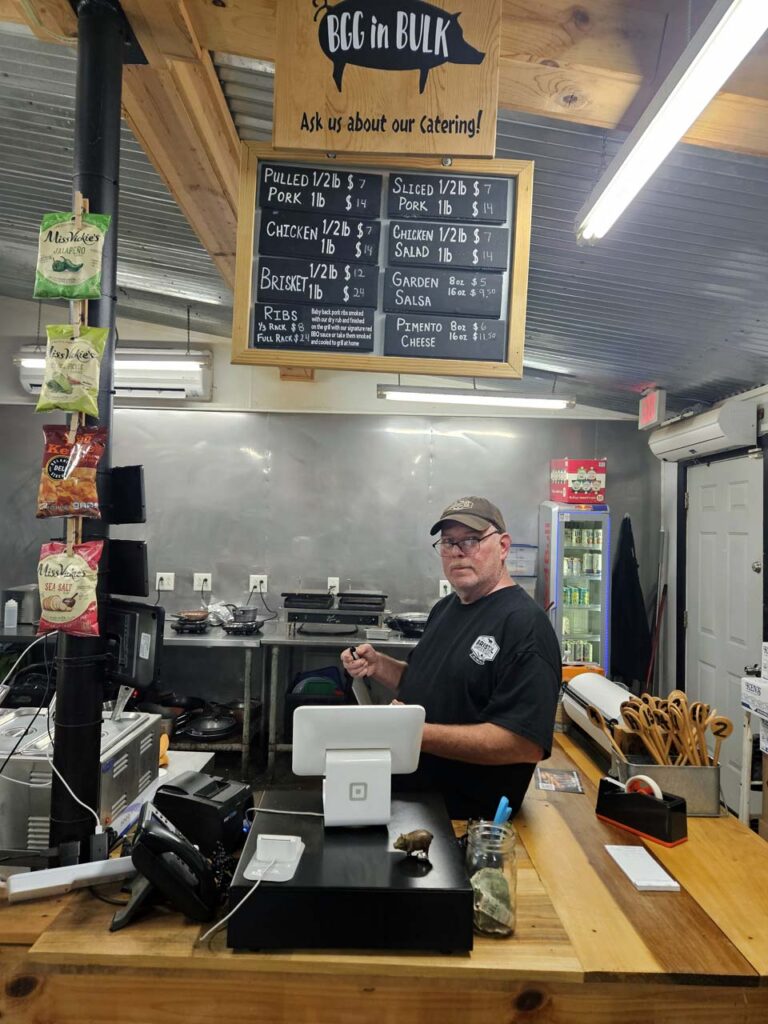 Matt Shy stands under menu signs