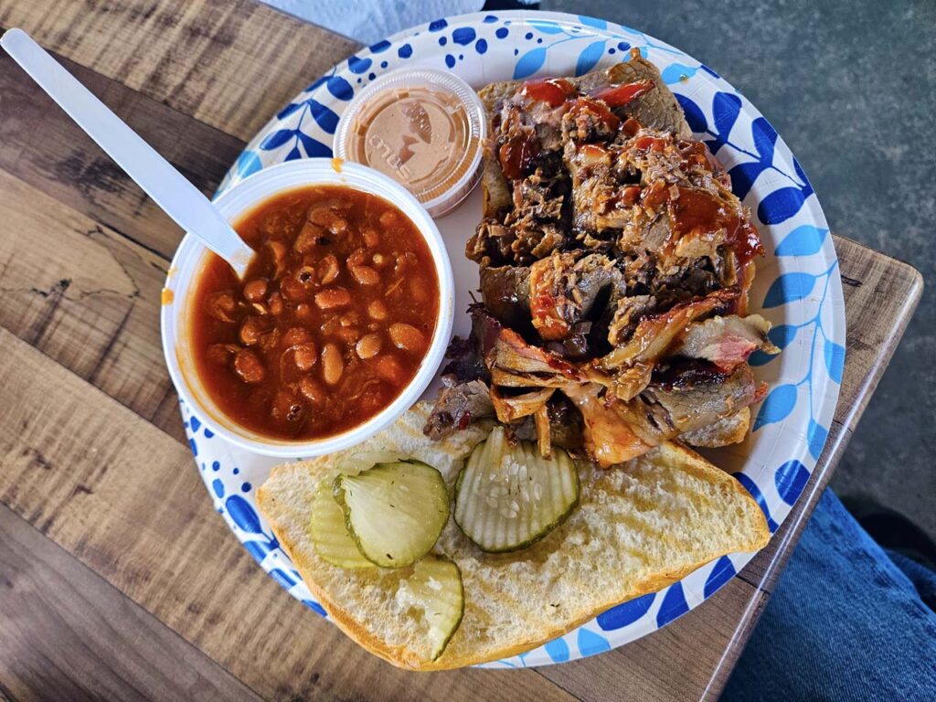 Beautiful Brisket Sandwich with a side of beans