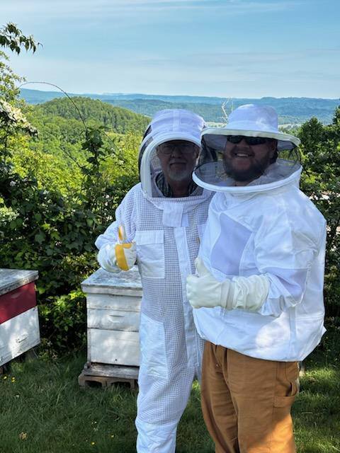 Jim and Travis with their beekeeping gear on.