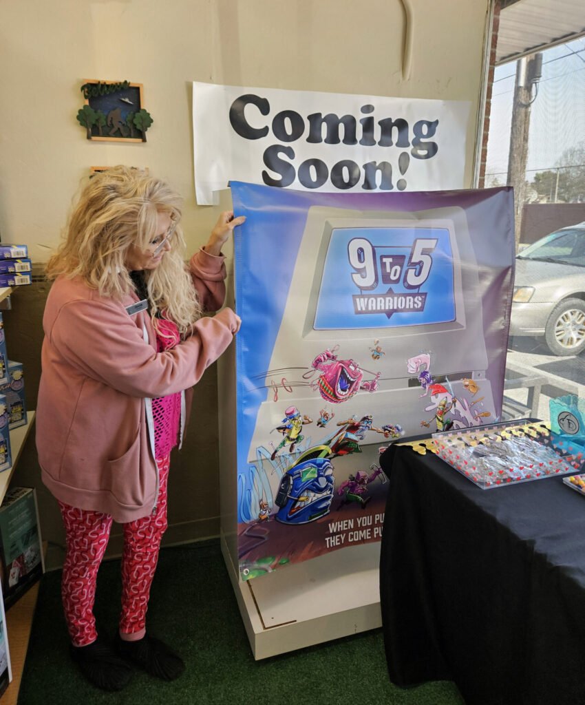 Anne Shell with the coming soon sign for 9 to 5 Warriors