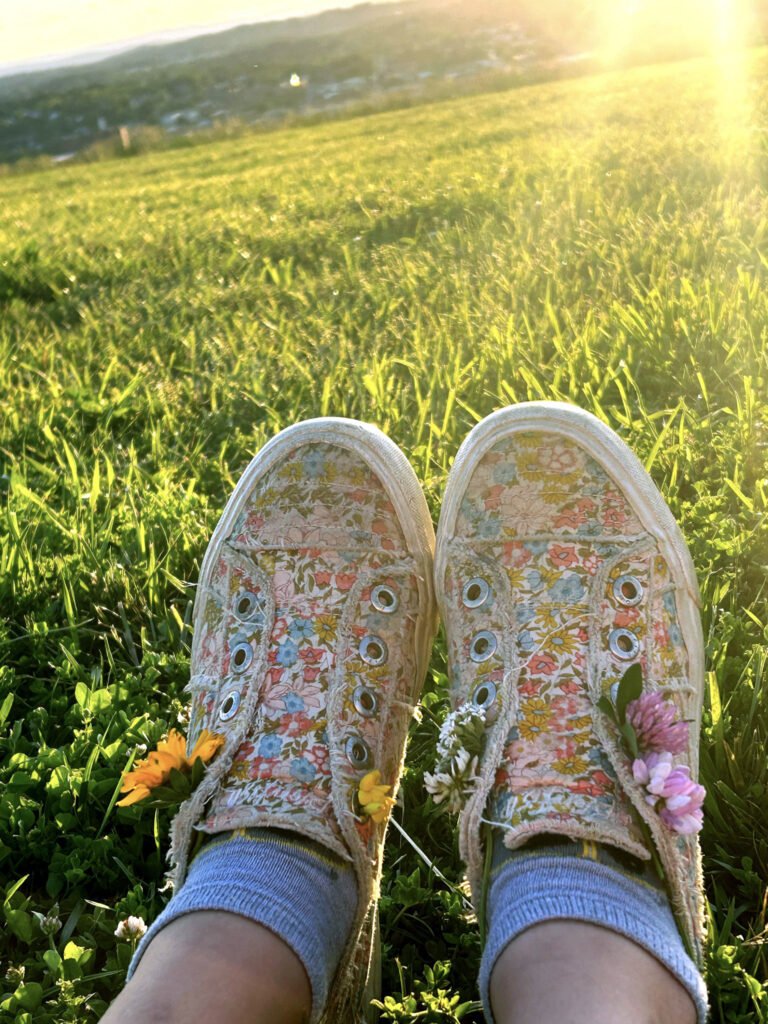 DgOLyDA9SVO8xDlAUjnUww - Appalachian Highlands Farmers Magazine Colorful shoes of a little girl lying in the grass, just before Sunset