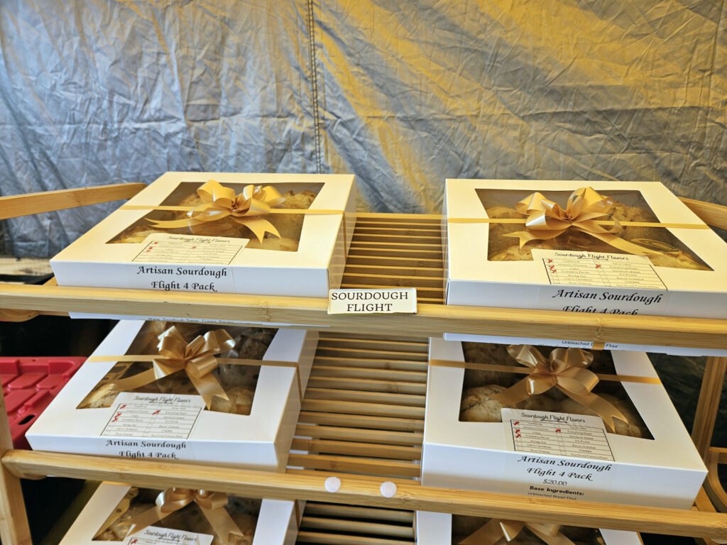 Boxes of Artisan Sourdough Flight 4 Pack with gold ribbons on a display shelf