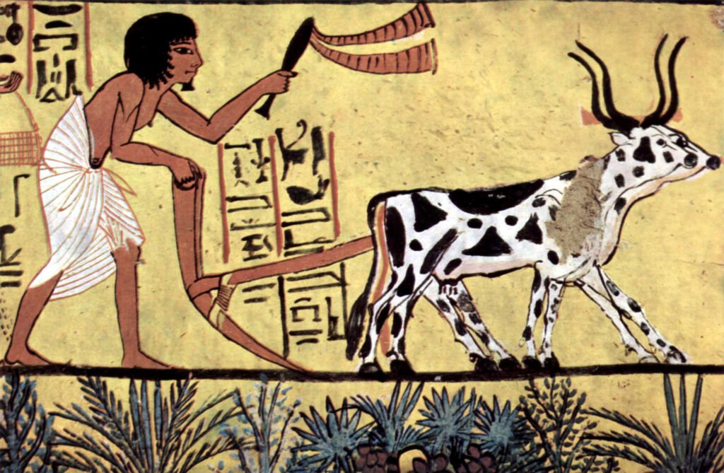 Ancient Egyptian wall painting of a man with a curved blade pursuing a horned, spotted animal along a line of text panels in a desert scene.
