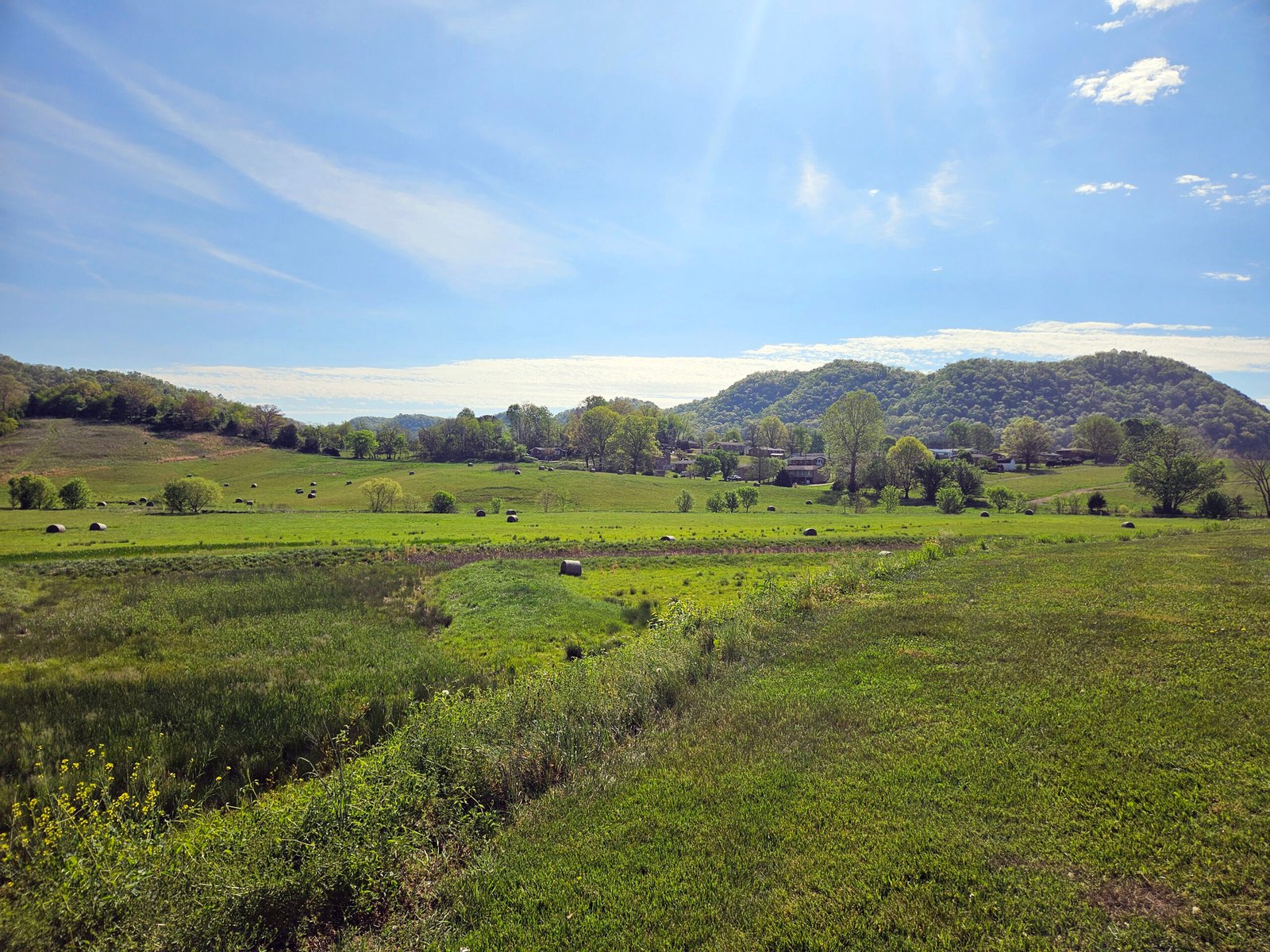 Farm scene with hay bails in the distance