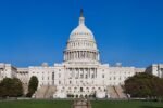 U.S. Capitol building with its white dome against a clear blue sky and manicured grounds in front