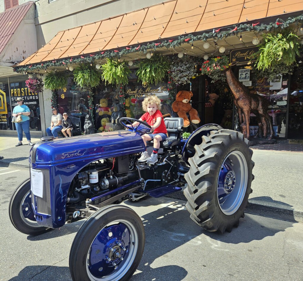 A little boy driving a 1951 Ford Tractor