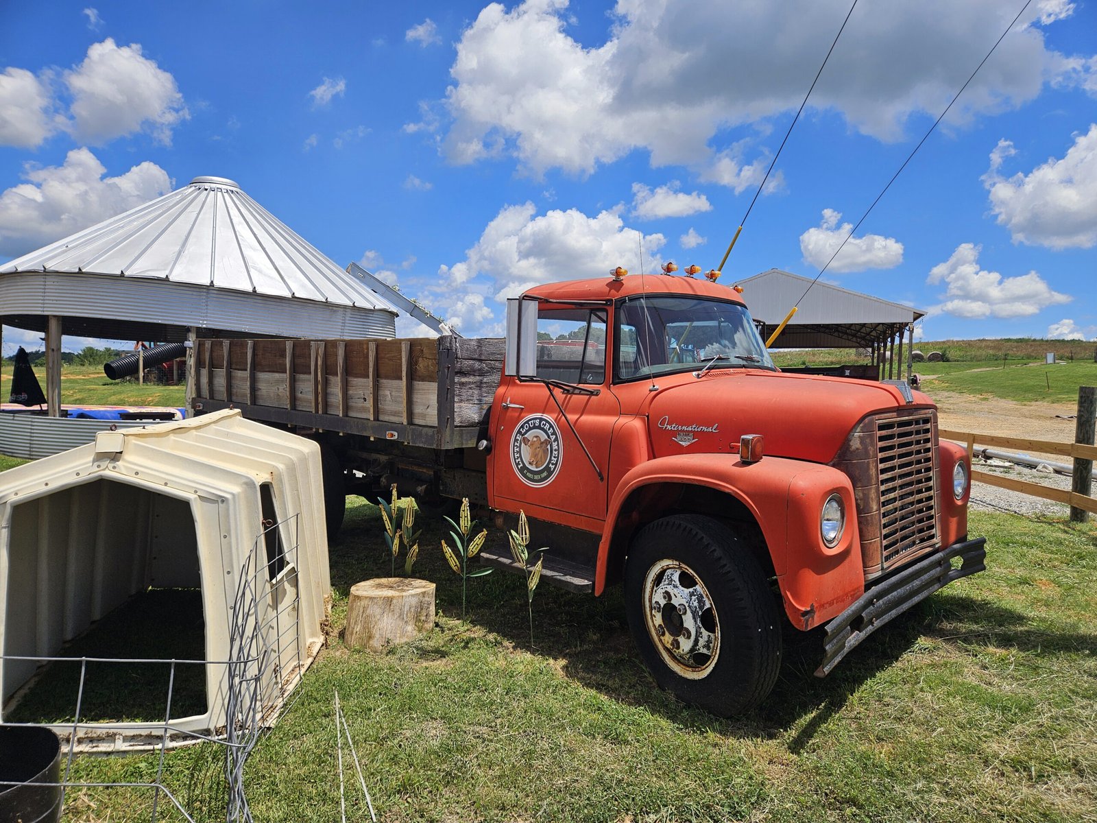 An old red farm truck with the logo of Horse Creek Farm and Little Lou's Creamery
