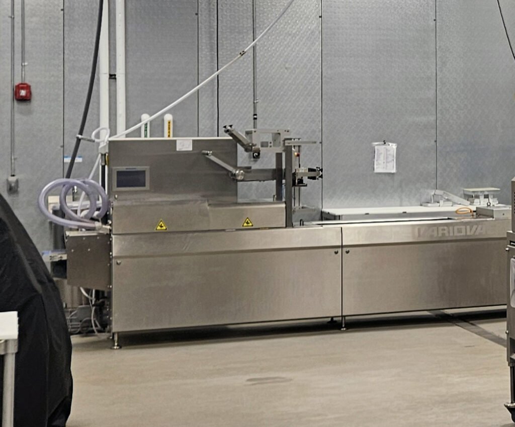 Packaging machine - Appalachian Highlands Farmers Magazine Variovac Optimus rollstock thermoforming machine, designed for automatic vacuum packaging.