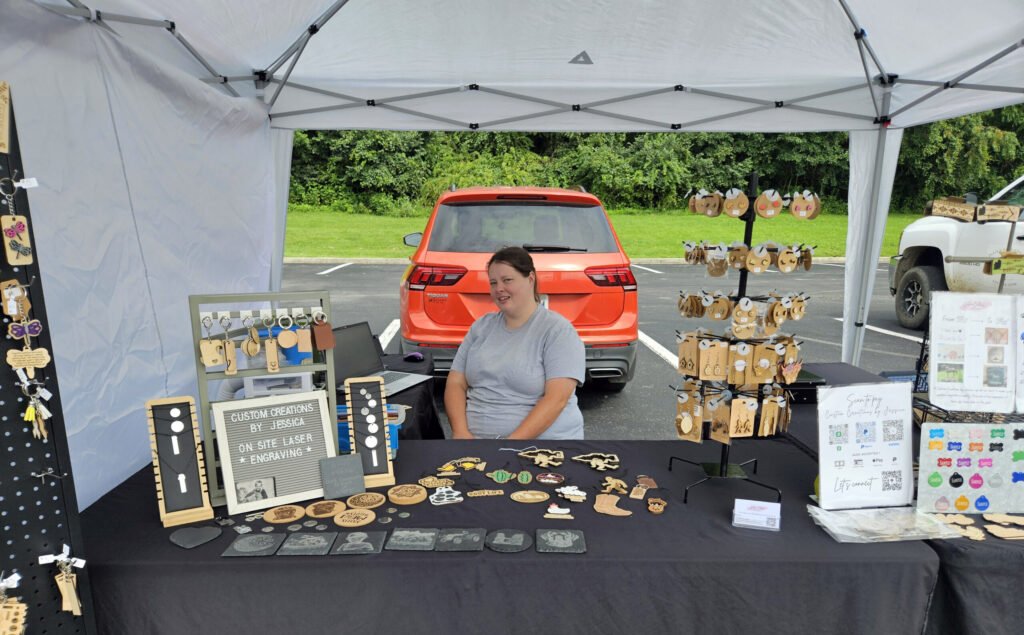 Jessica from Custom Creations by Jessica sitting with some of her work.
