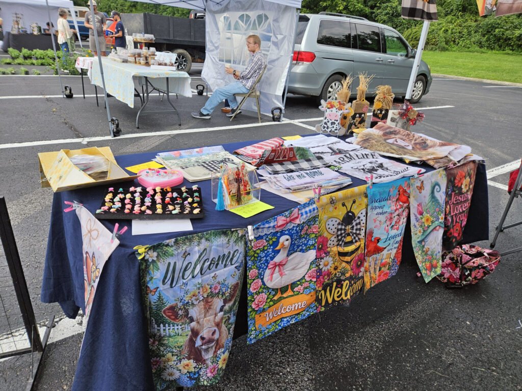 A vendor selling Welcome signs, stuffed items, jewelry, and other items.