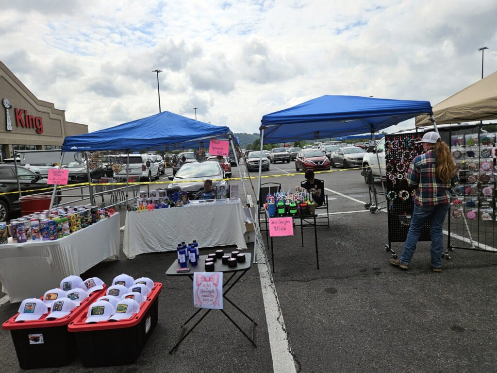 A vendor selling caps with messages on them and tumblers with artwork.