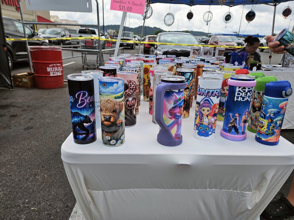 A vendor selling caps with messages on them and tumblers with artwork.