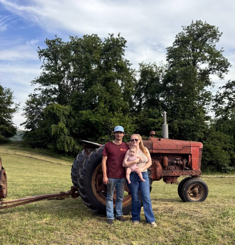 Jackson and Keelie Fleenor and Baby LeDoux in front of the Farmall M