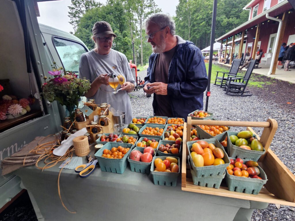 Jill O'Dell helps a customer with tomatoes and honey.