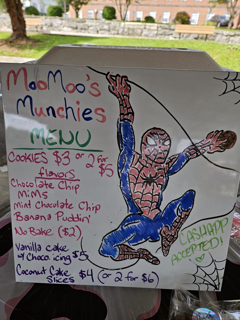 A handmade sign with Spider Man with a menu of items available at Moo Moo's at the Marion Farmers Market - Photo by A. Creighton