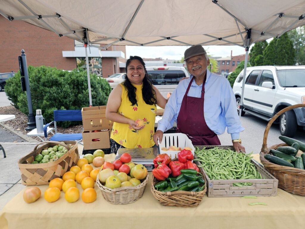 Norma and Dario - Appalachian Highlands Farmers Magazine Norma Sierra and Dario of Our Backyard Farm with fresh peppers, Tomatoes, peaches, and tomatillos