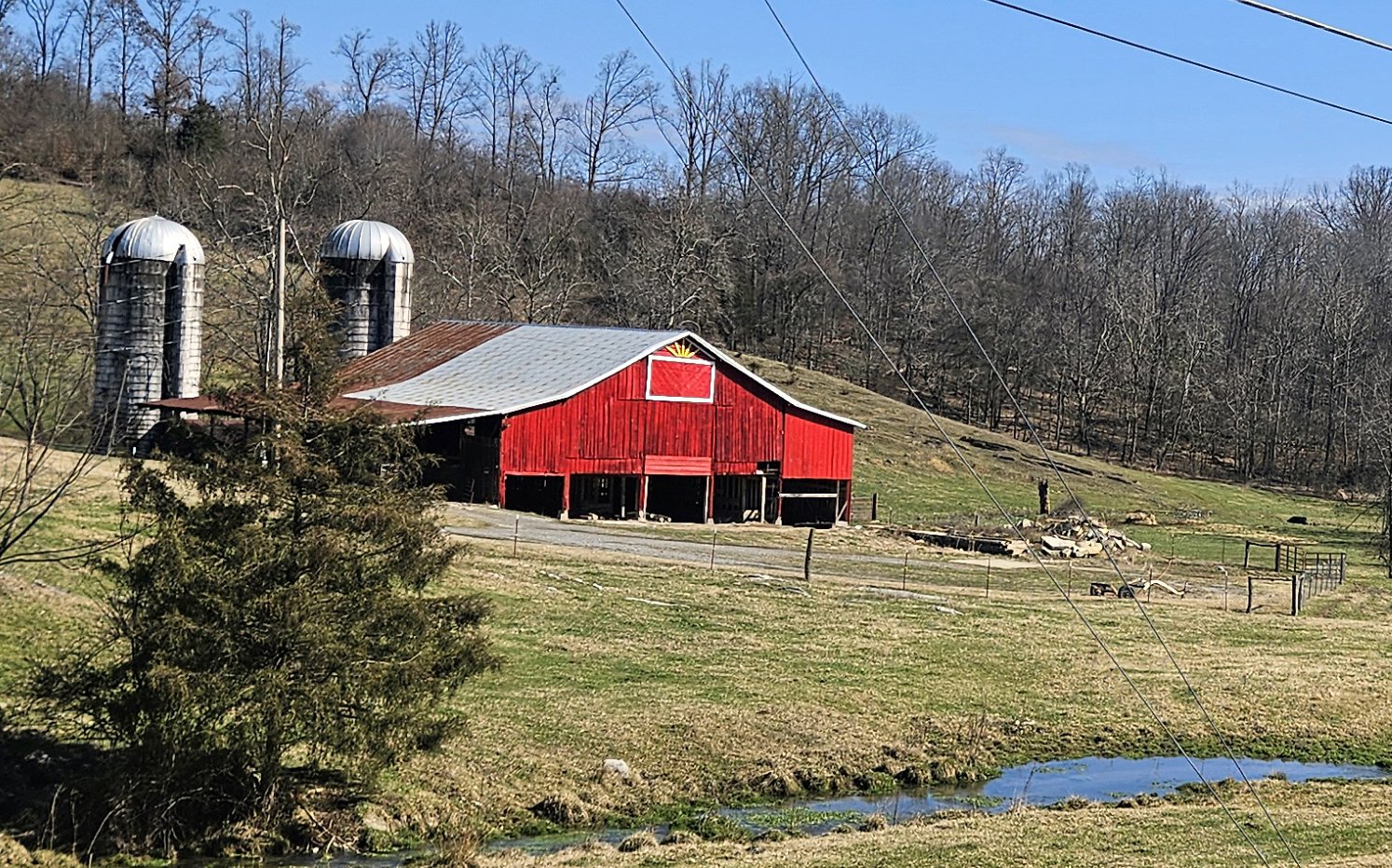 Red barn with two silos and a field with livestock in front. Farm Beginnings Info Session