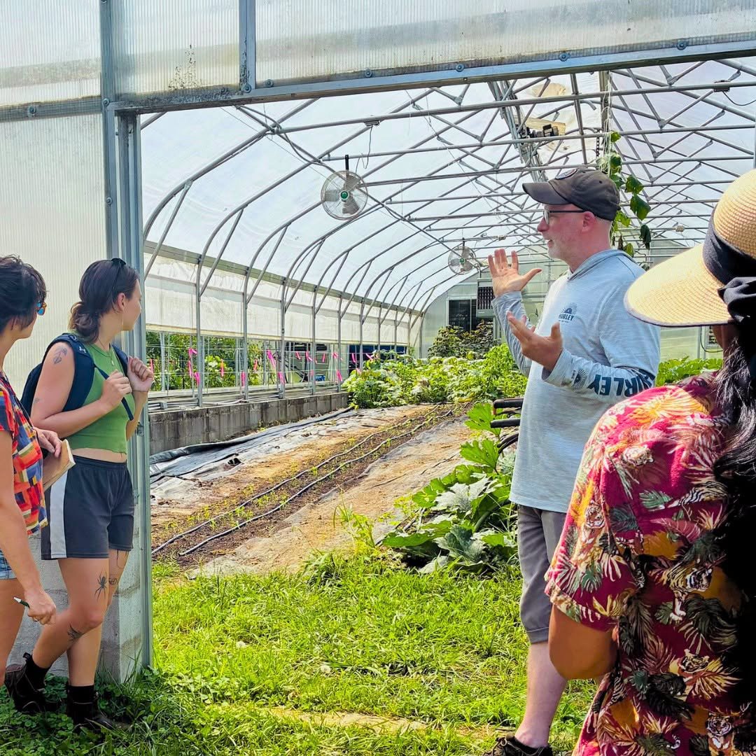 An instructor and students standing at the door of a high tunnel. 11. Farm Beginnings Info Session